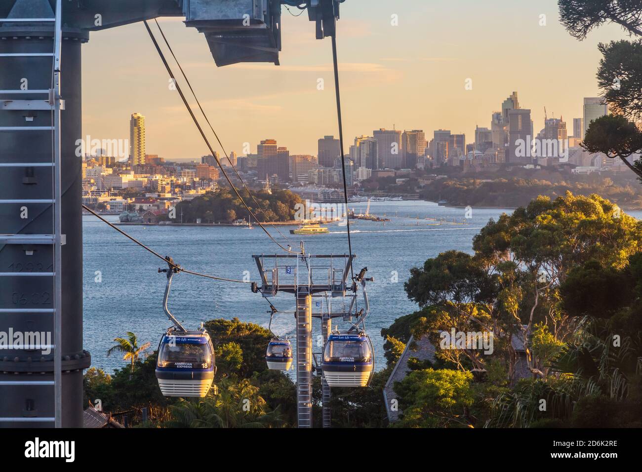 Cable cars at Taronga Zoo, Sydney, Australia. In the background, the city skyline is bathed in warm sunset light Stock Photo