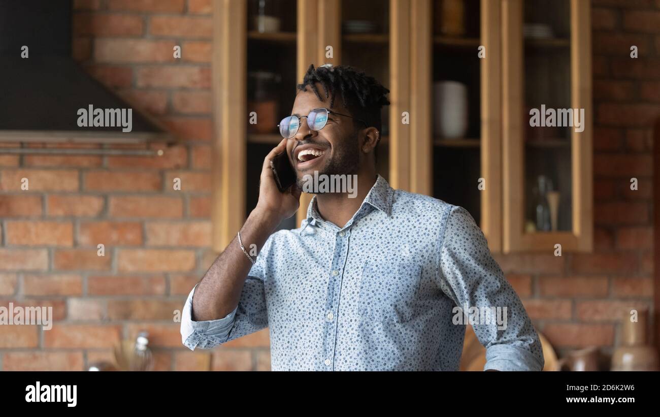 Smiling young biracial man laugh talking on cellphone Stock Photo