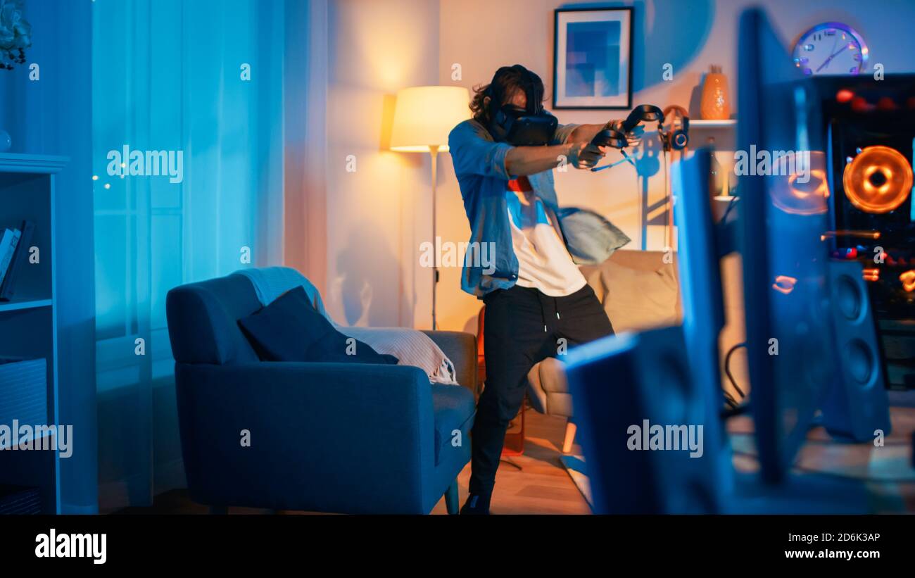 Young Man is Energetically Playing a Virtual Reality Video Game While ...