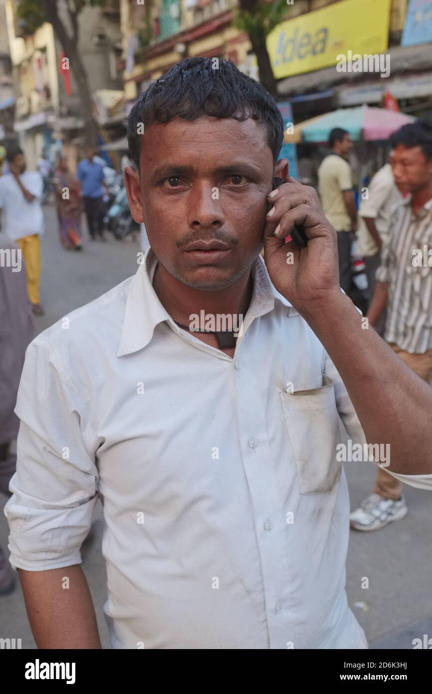 A man in Mumbai, India, earnestly, intensely listening to his conversational partner on the mobile phone, and possibly surprised by the photographer Stock Photo