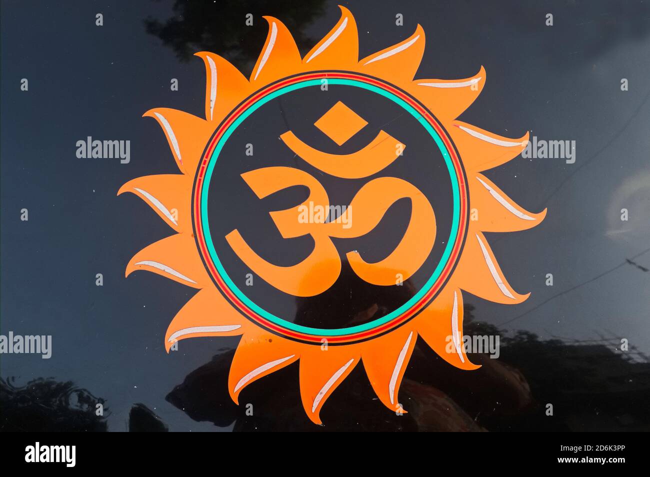 The sacred Hindu OM or Aum symbol painted on the hood of a taxi, with surroundings mirrored on the hood; Mumbai, India Stock Photo