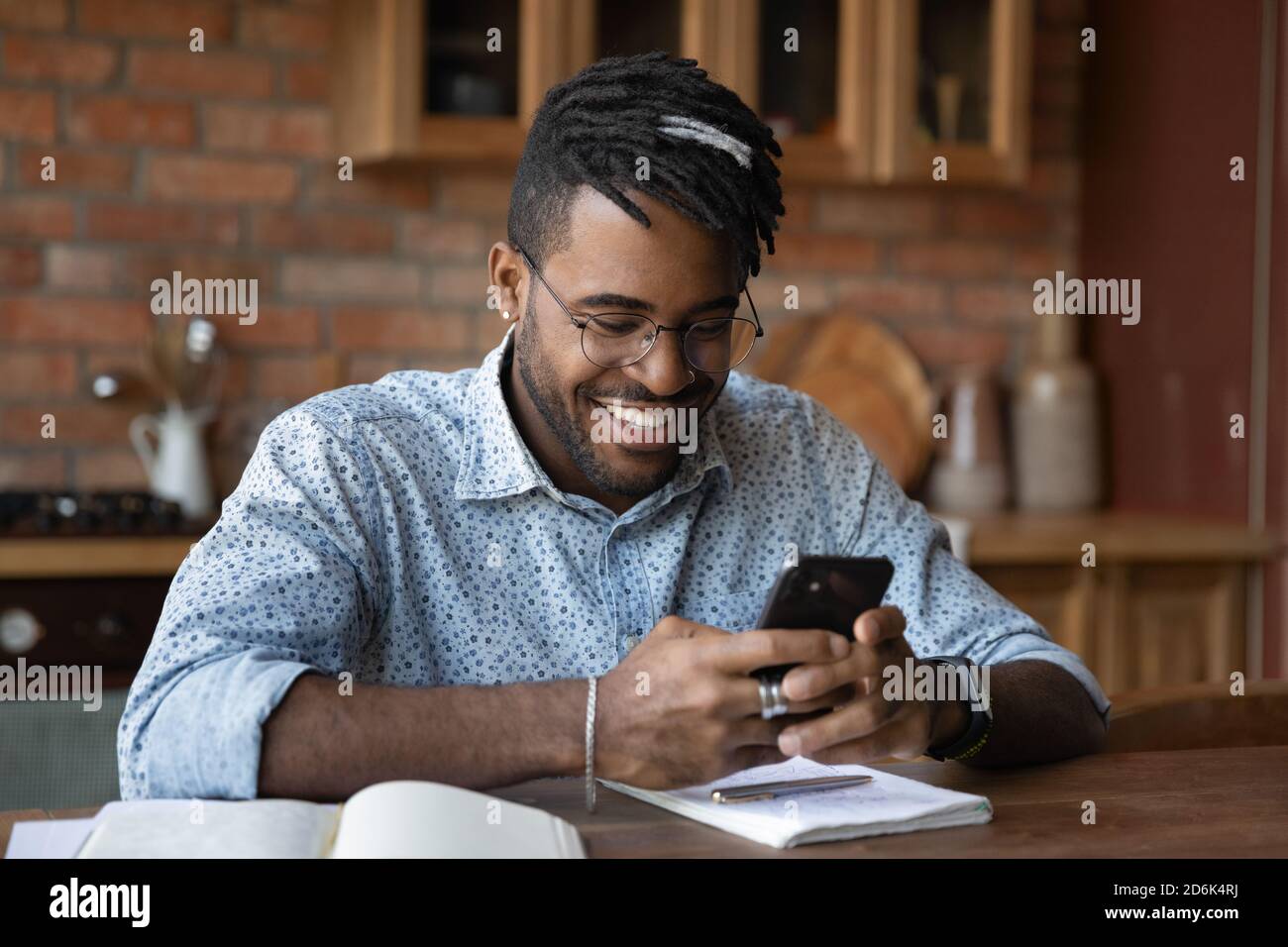 Smiling biracial man use modern cellphone texting Stock Photo
