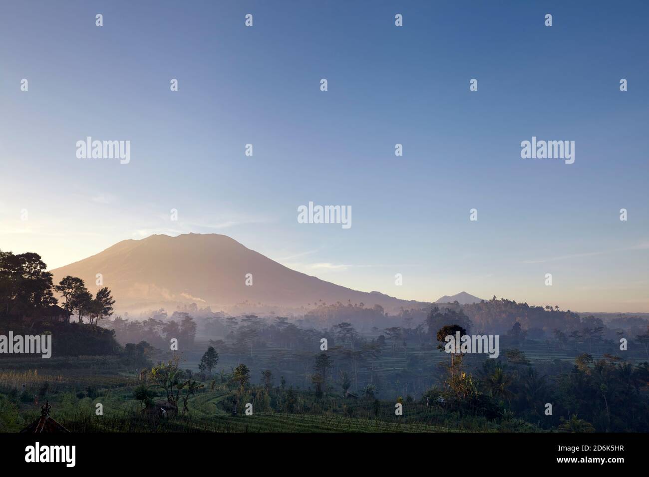rice terraces, farmland, fields and exuberant jungle vegetation in front of Mount Agung Stock Photo