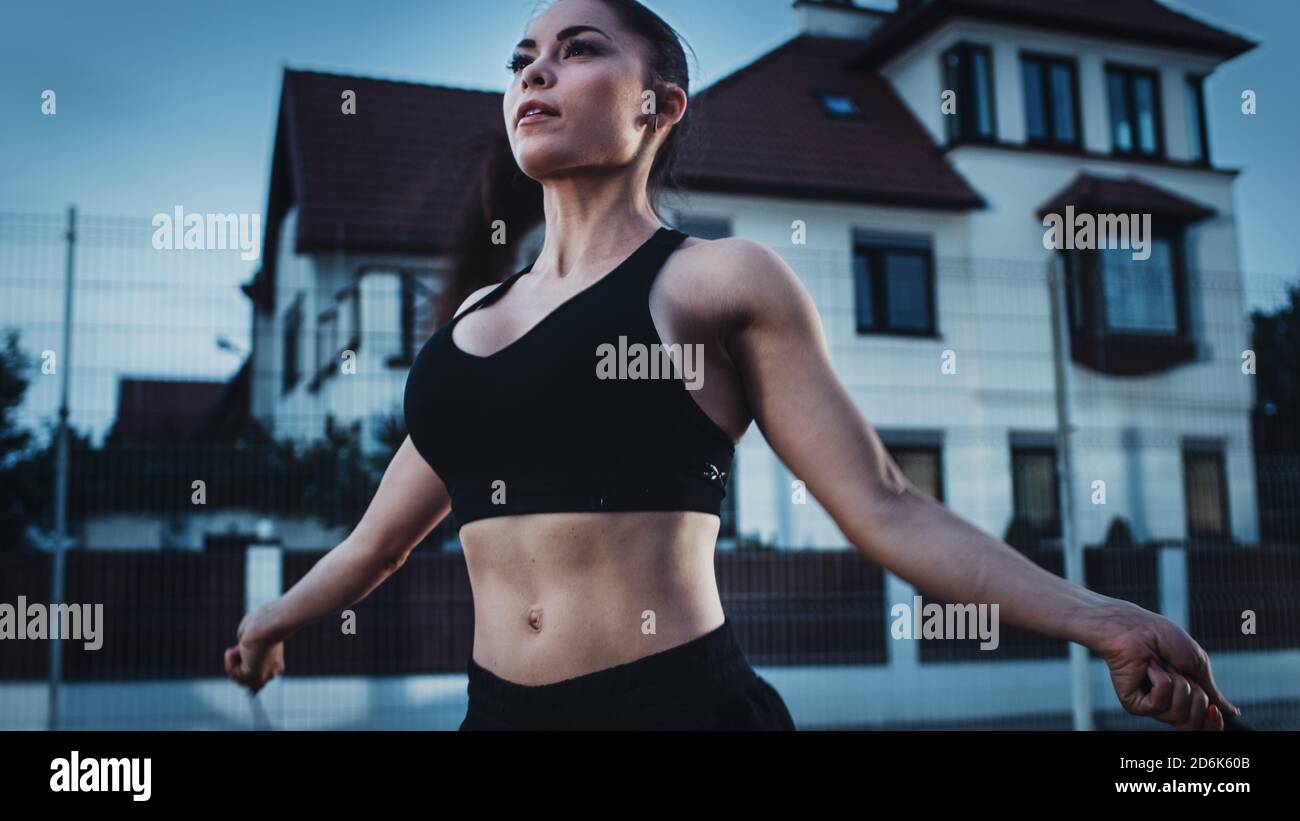 Close Up Shot of a Beautiful Busty Fitness Girl Skipping/Jumping Rope. She  is Doing a Workout in a Fenced Outdoor Basketball Court. Evening Shot After  Stock Photo - Alamy