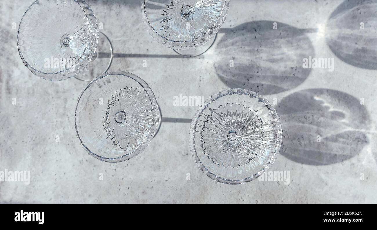 Top view of collection of shiny glass goblets casting shadows on table ...