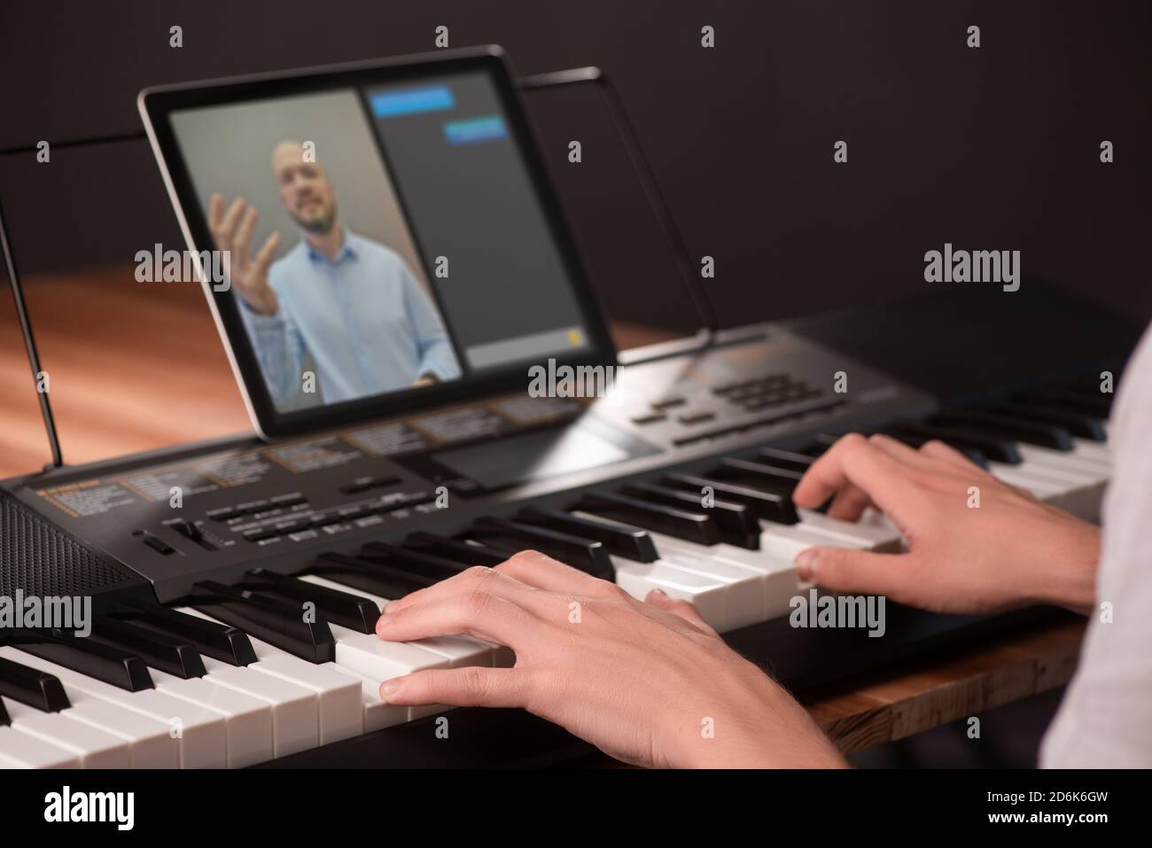 Young man learning to play piano, using keyboard and tablet with app Stock  Photo - Alamy