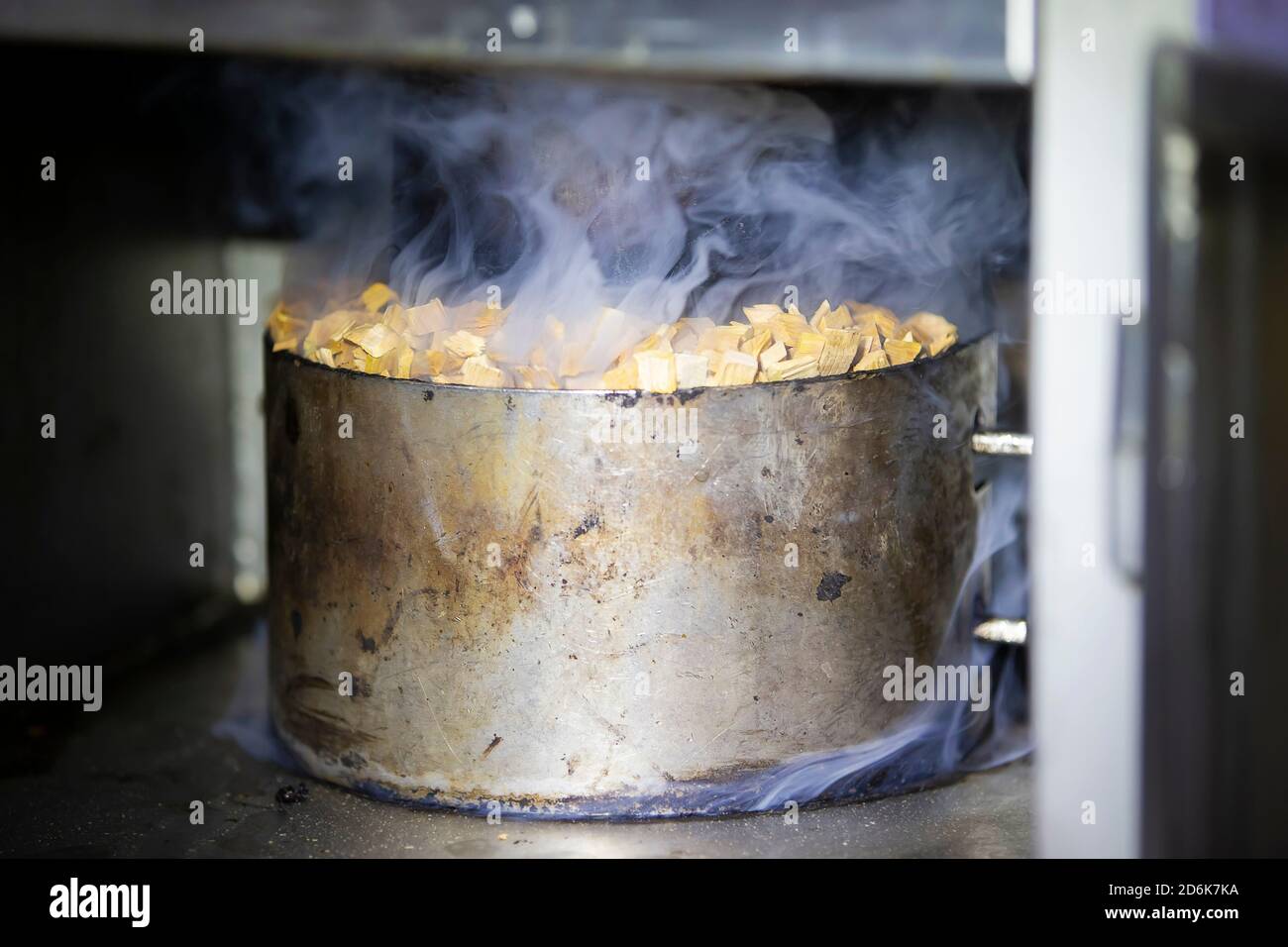 Metal pot with sawdust and smoke in an industrial oven for smoking fish Stock Photo Alamy