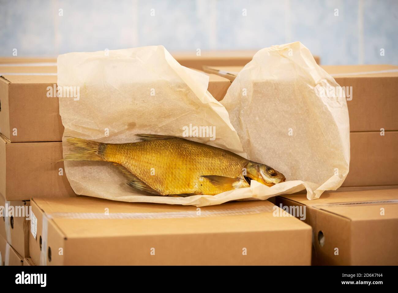 Smoked mackerel lies on cardboard boxes in a warehouse. Stock Photo