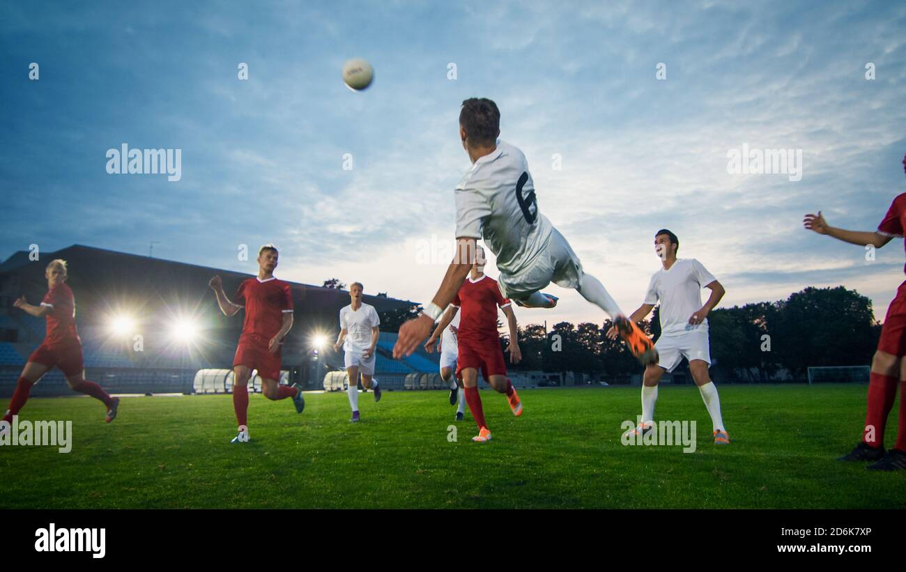 Soccer Player Receives Successful Pass and Kicks Ball to Score Amazing Goal doing Bicycle Kick. Shot Made on a Stadium Championship. Stock Photo