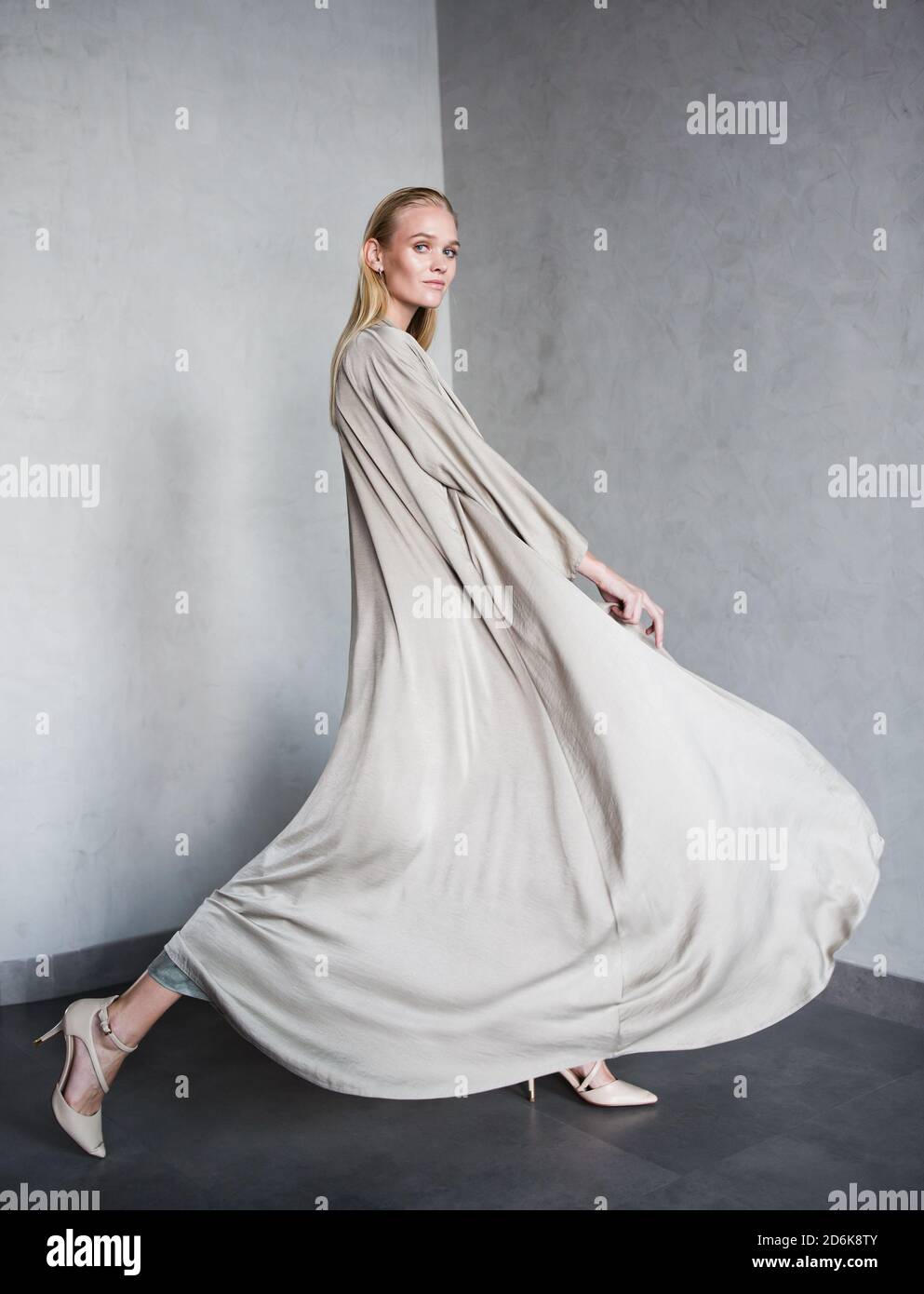 Gorgeous female fashion model wearing a luxury abaya posing while walking in a studio. Stock Photo