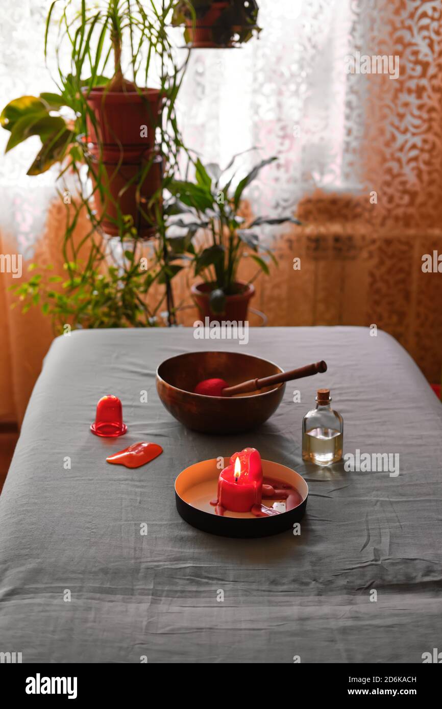 Massage at home. Oil, singing bowl, vacuum can and scented candle on