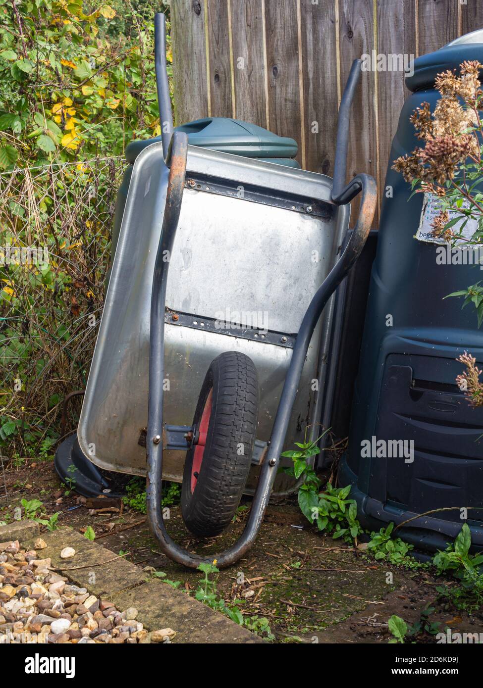 Wheel barrow and compost bins garden Stock Photo Alamy