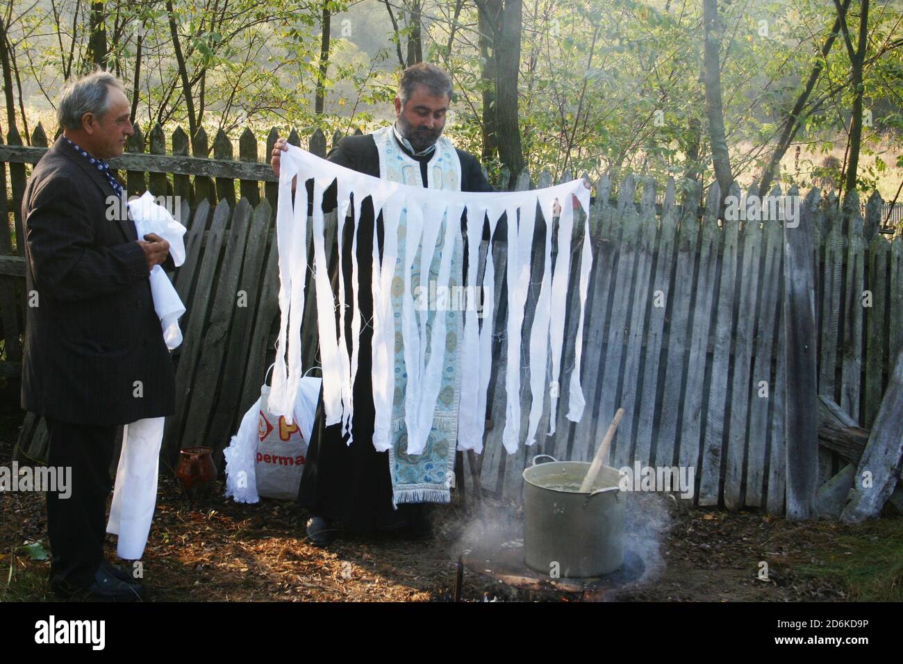 Romanian Orthodox priest preparing 'tarnoseala': cloth dipped in a mixture of  wax, frankincense & myrrh, given to believers at a church consecration Stock Photo