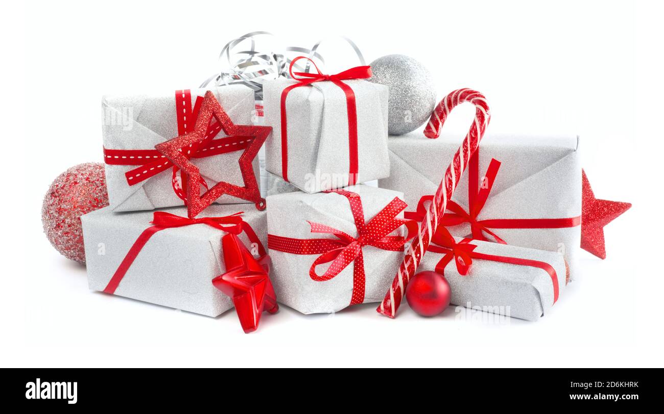 Heap of similar Christmas silver gift boxes with red ribbon decor stars baubles and candy cane isolated on white background Stock Photo