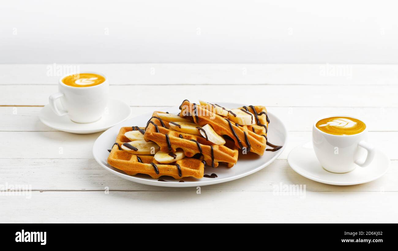 Homemade belgian waffles with banana slices topped with chocolate and ...