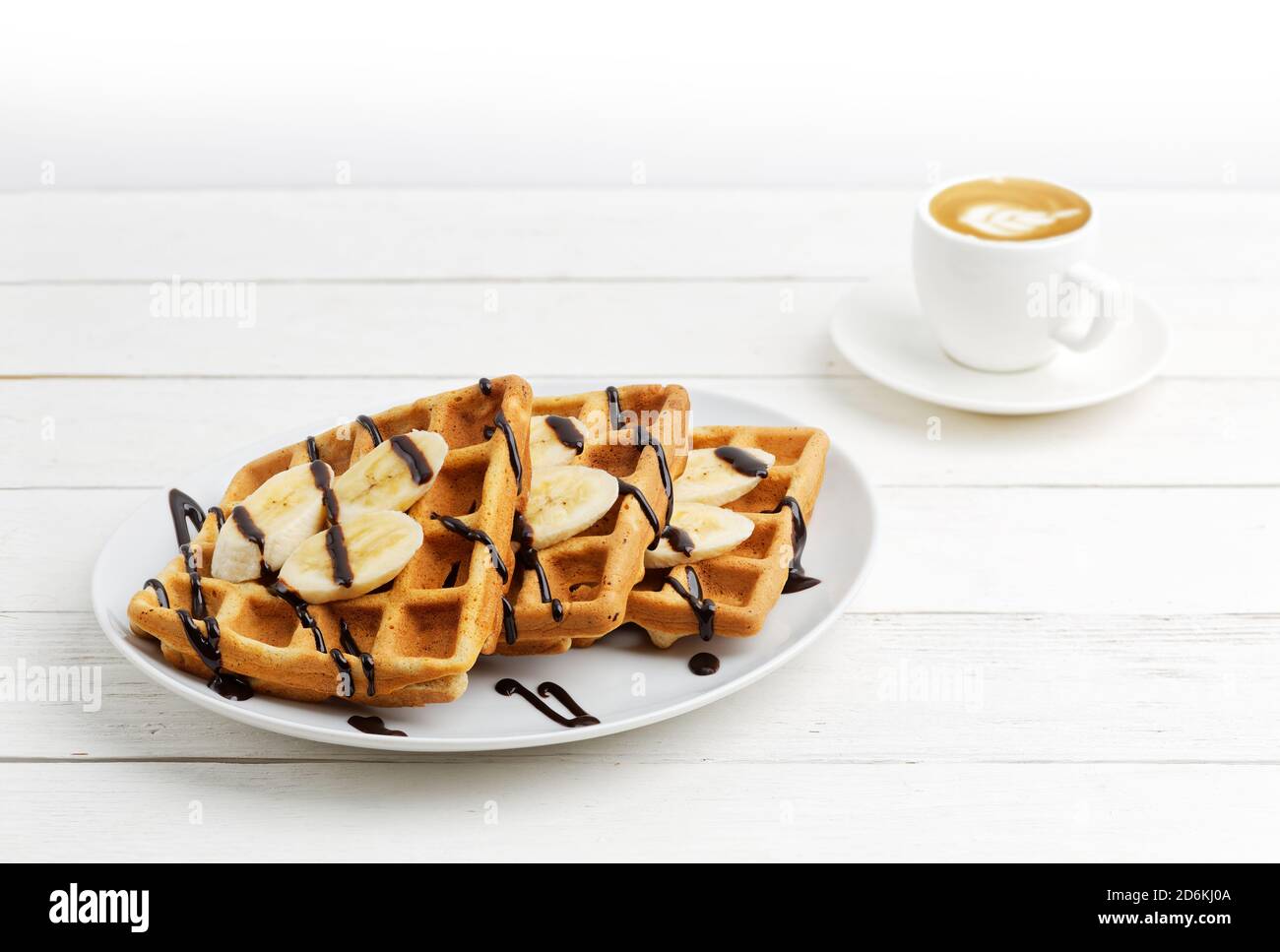 Homemade belgian waffles with banana slices topped with chocolate and ...