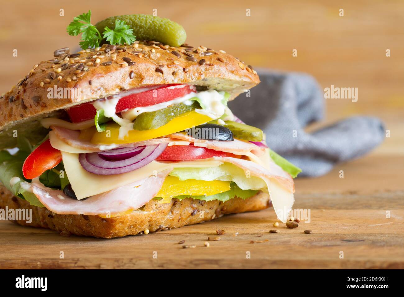 Appetizing sandwich with cured meat, cheese and vegetables on wooden background Stock Photo