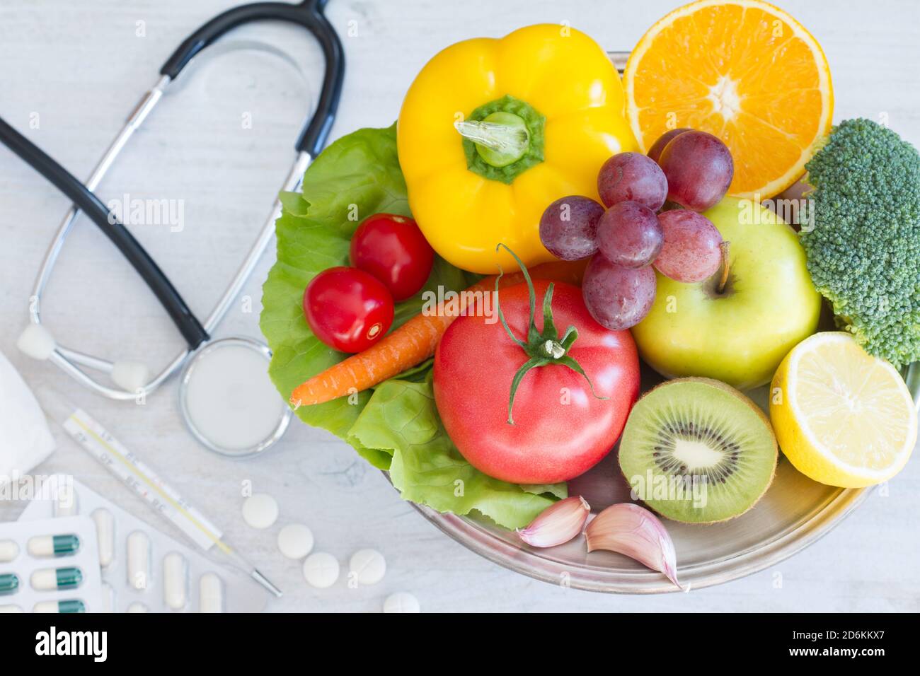 Fruits and vegetables platter, medications in background. Healthy diet alternative Stock Photo