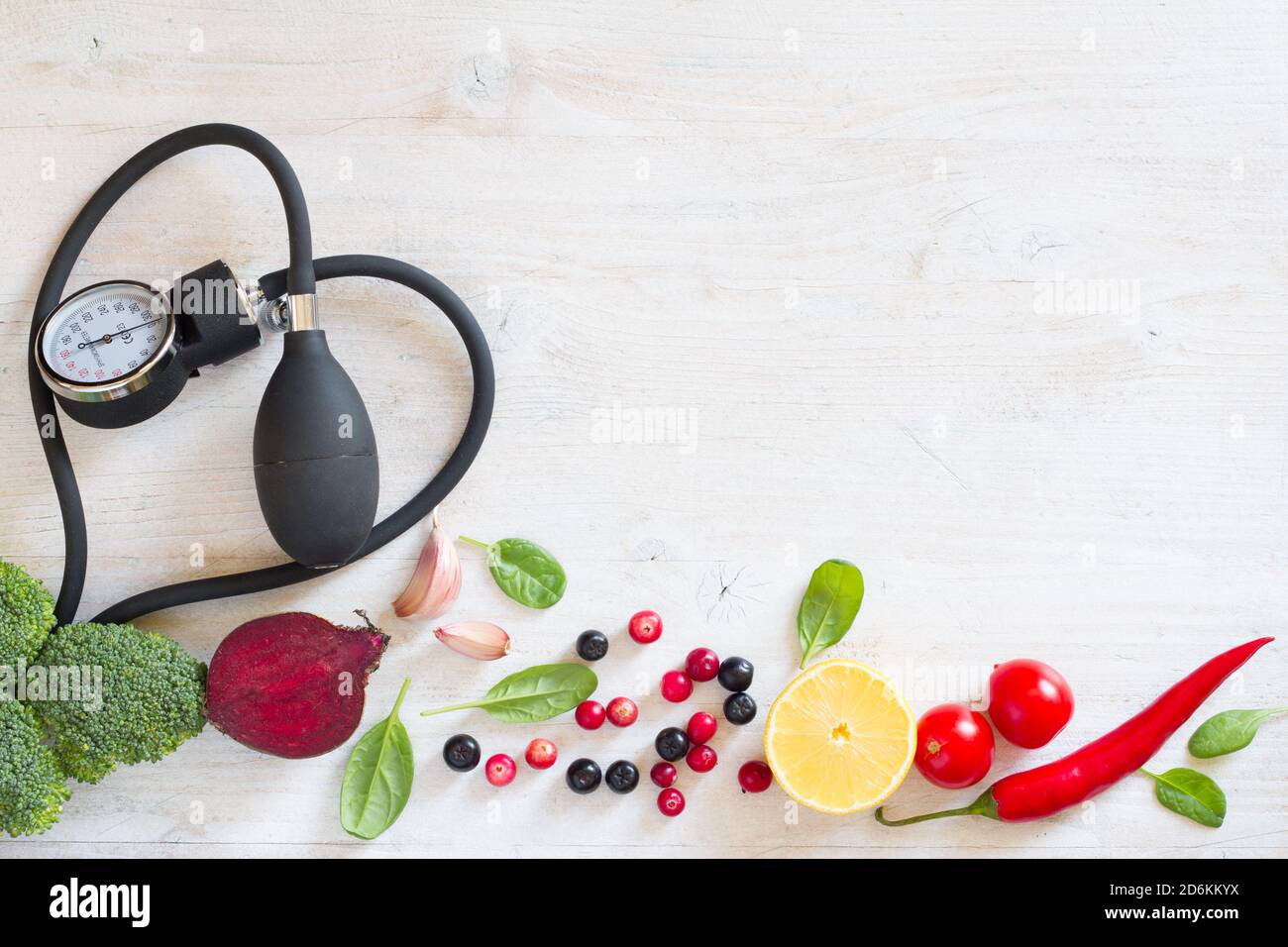 Heartshaped blood pressure monitor and vegetables with fruits to