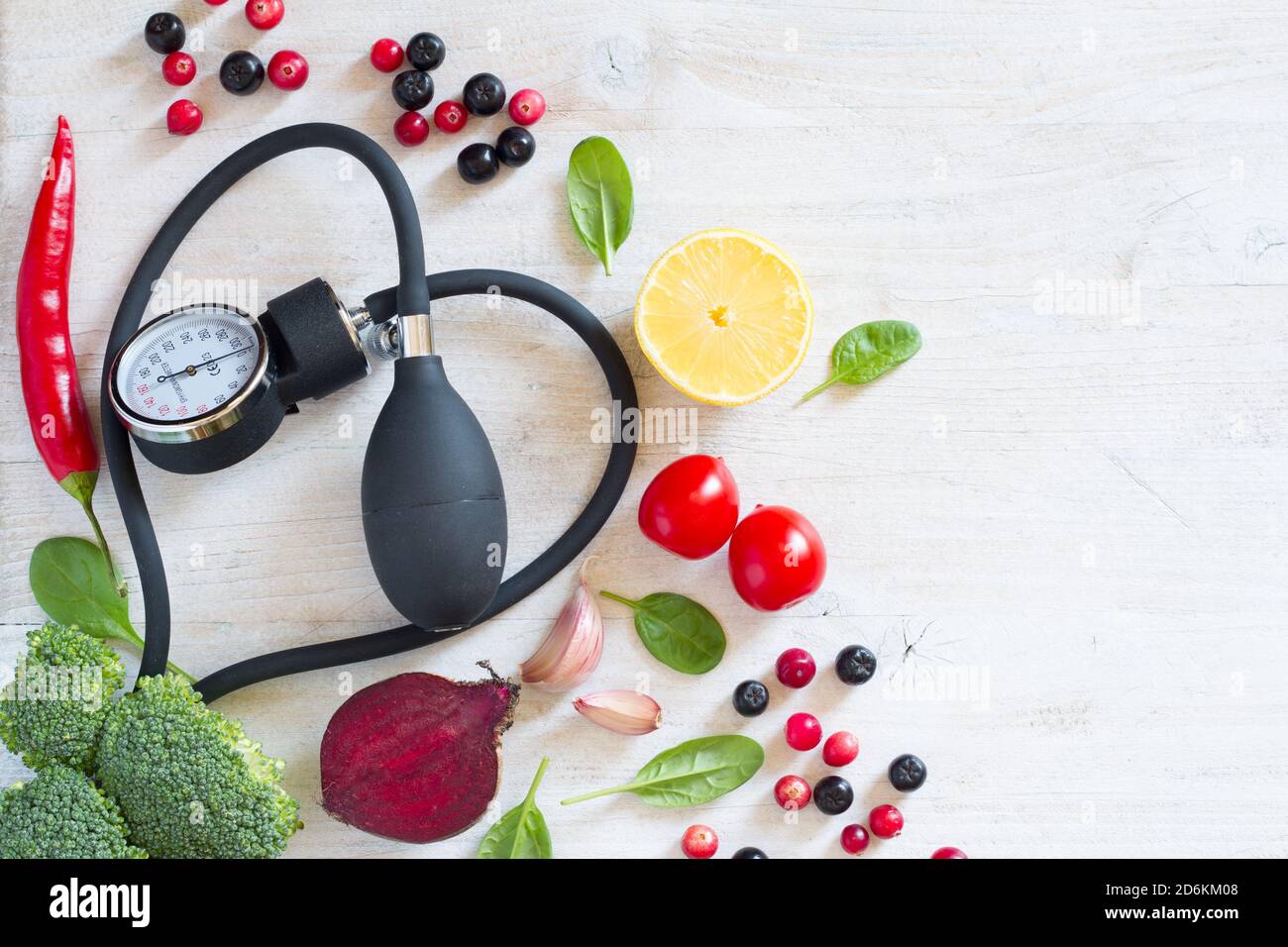 Heart-shaped blood pressure monitor and vegetables with fruits to prevent hypertension, healthy diet concept Stock Photo
