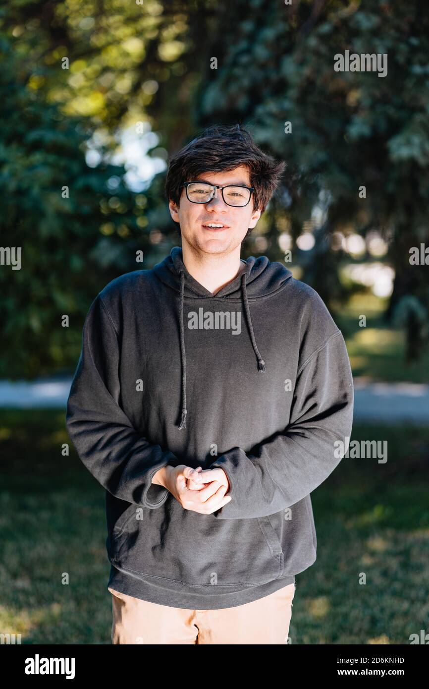 Portrait of happy young male student with glasses in casual outfit ...