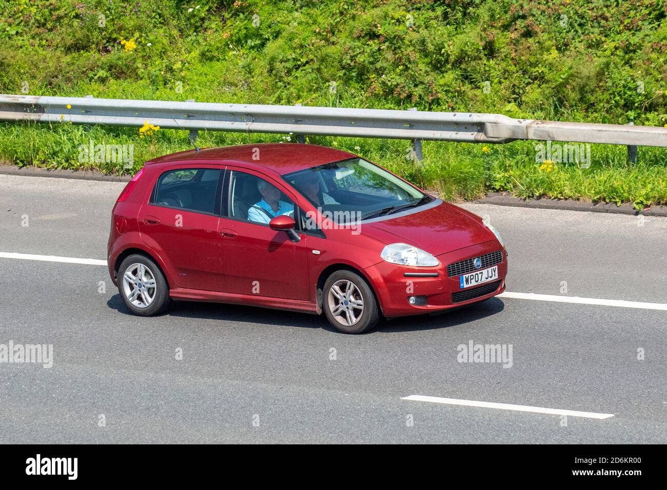 2007 red Fiat Grande Punto Dynamic; Vehicular traffic, moving vehicles, cars, vehicle driving on UK roads, motors, motoring on the M6 motorway highway UK road network. Stock Photo
