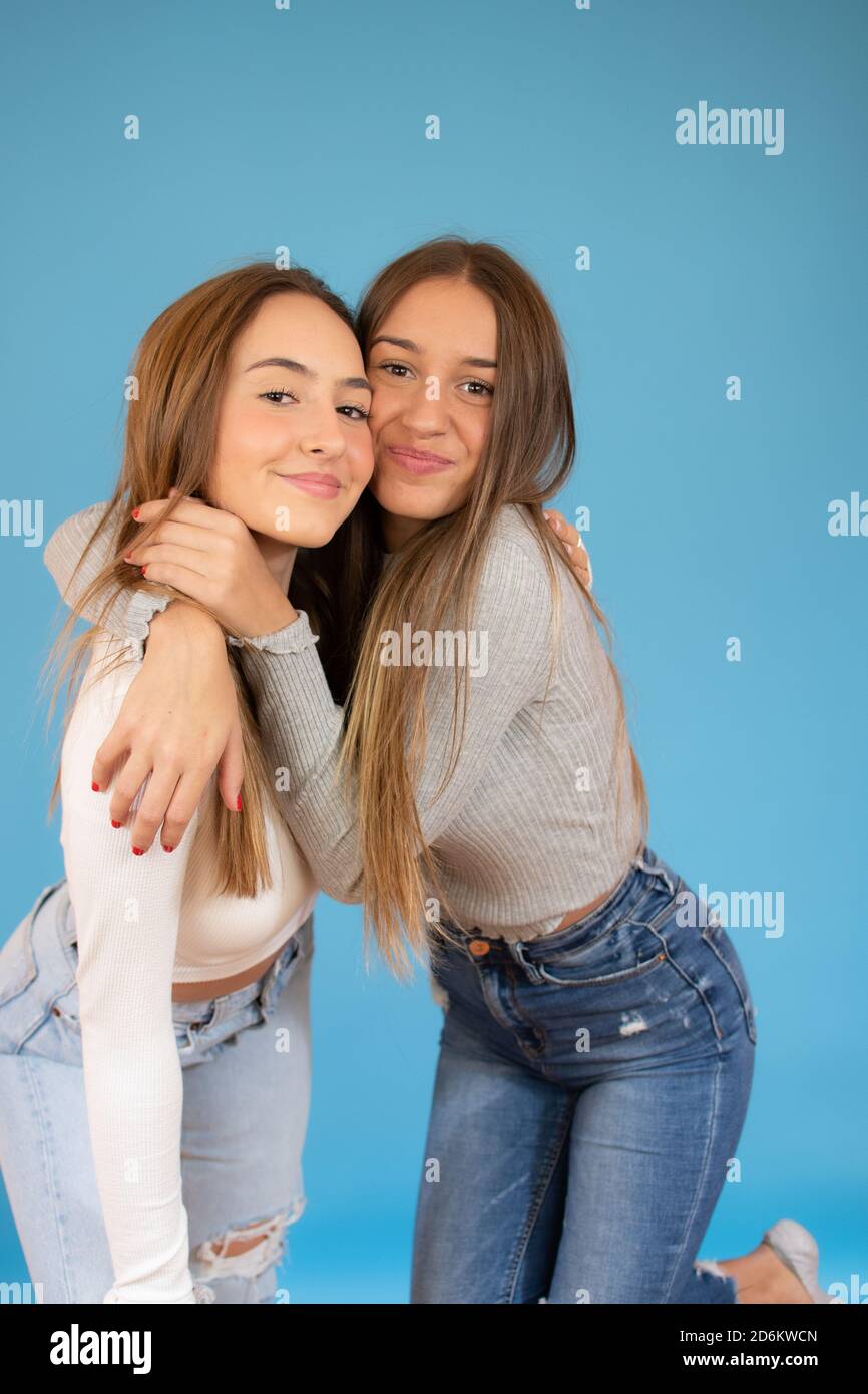 happy smiling pretty teenage girls hugging over blue background Stock ...