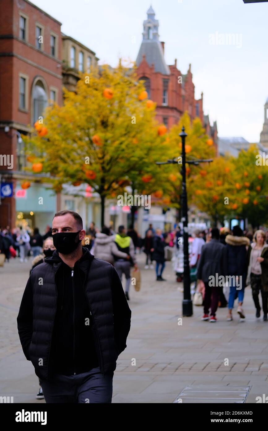 Manchester / United Kingdom - October 17, 2020: Manchester street during pandemic. Young man wearing black face mask. Stock Photo