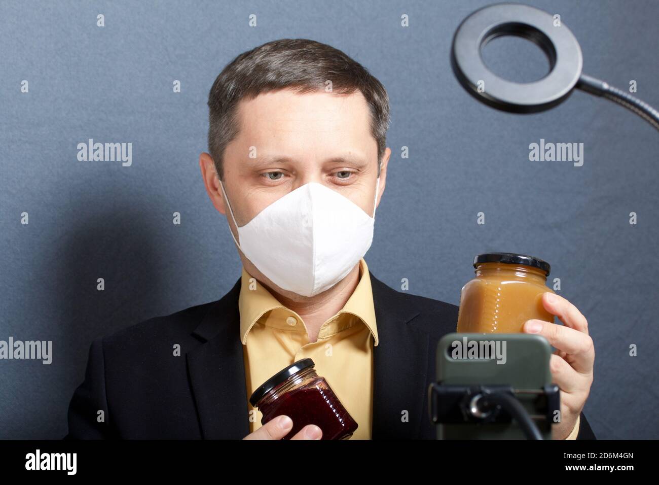A man in a suit without a tie. Medical mask on the face. Demonstrates