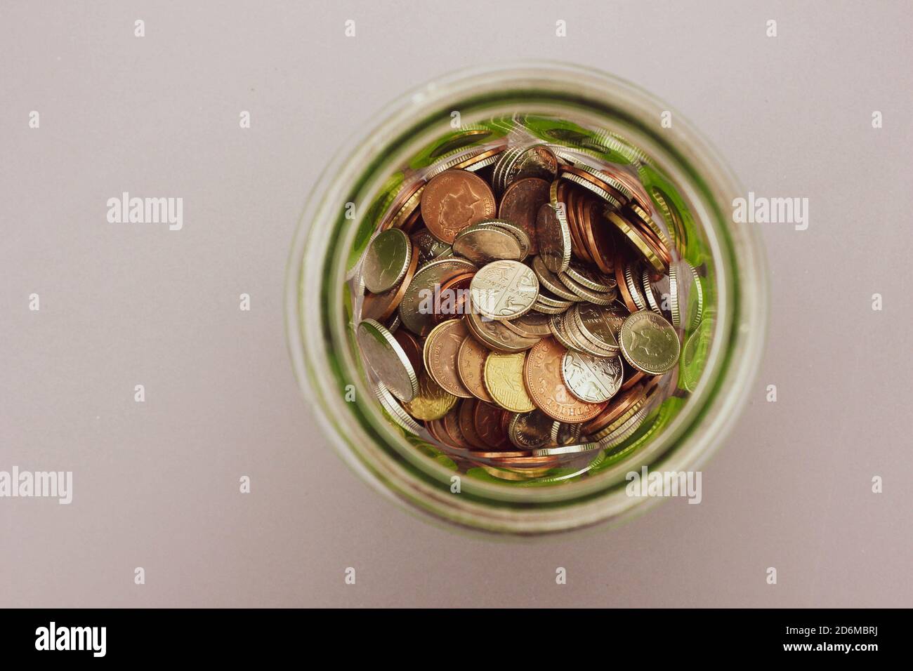Money jar full of coins. Taken from above. Space for copy. Stock Photo