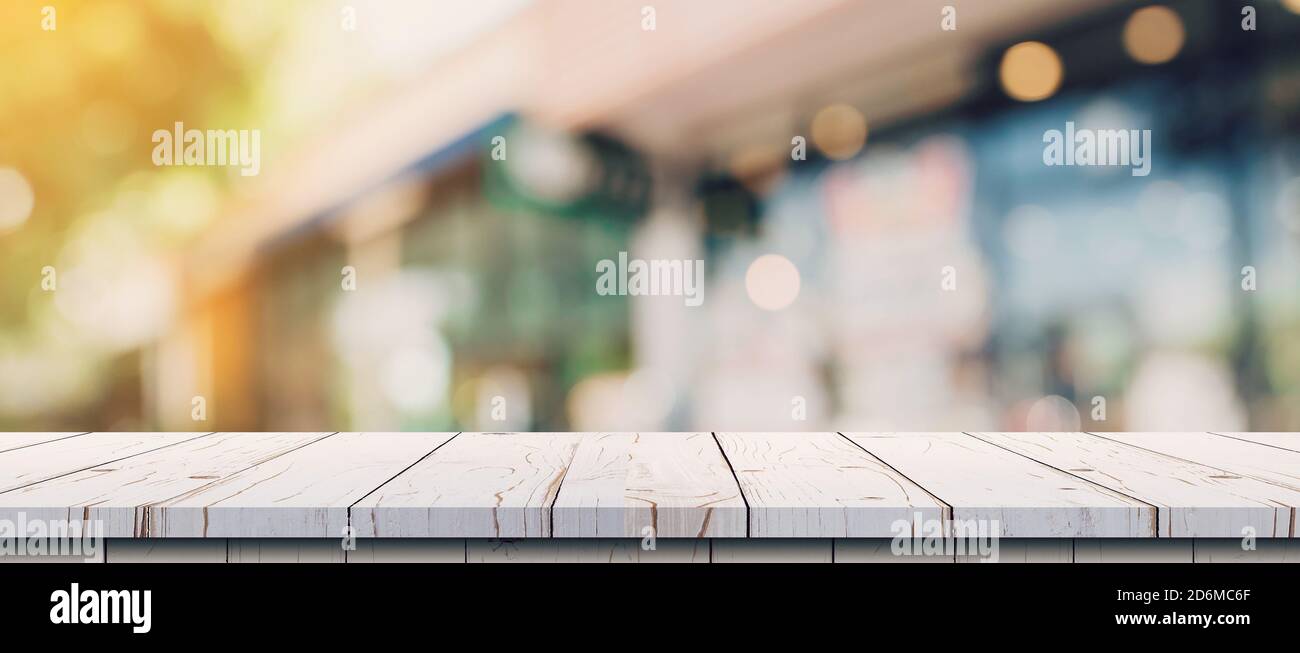 Empty wood table and blurred light table in coffee shop and cafe with ...