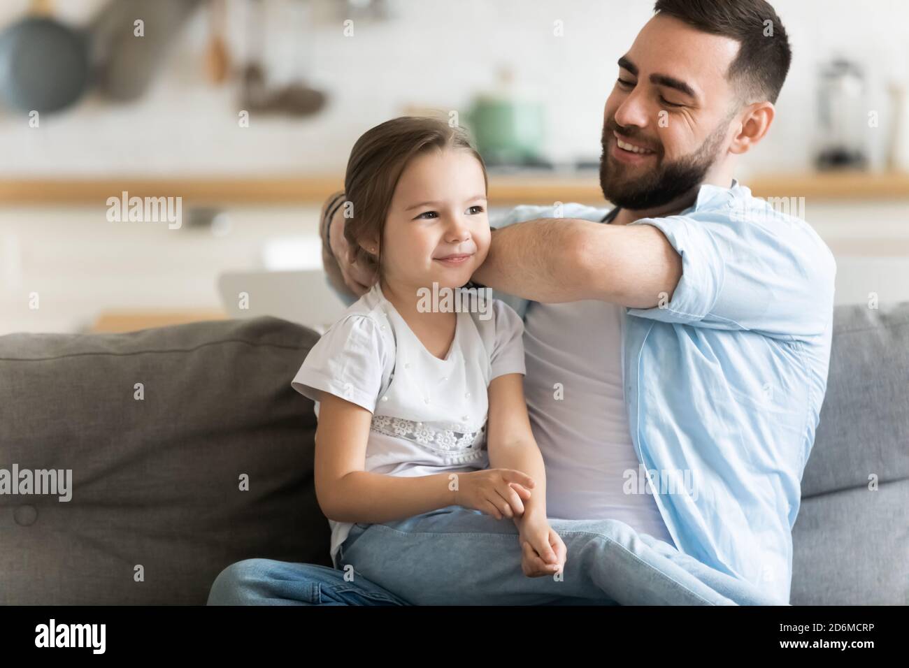 Caring smiling father brushing combing adorable preschool daughter hair Stock Photo