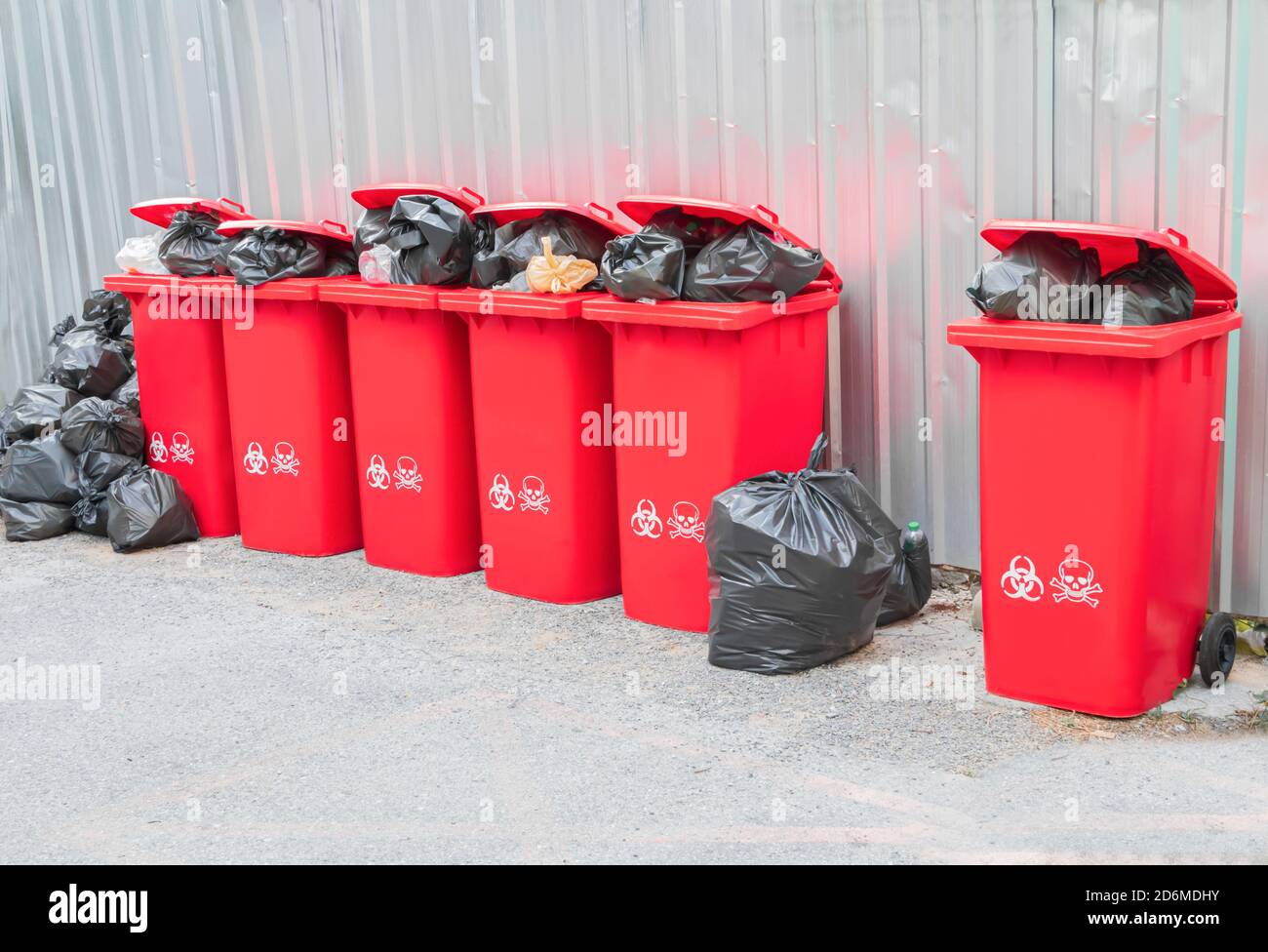 group red bins six with symbol infectious and garbage bag black pile On