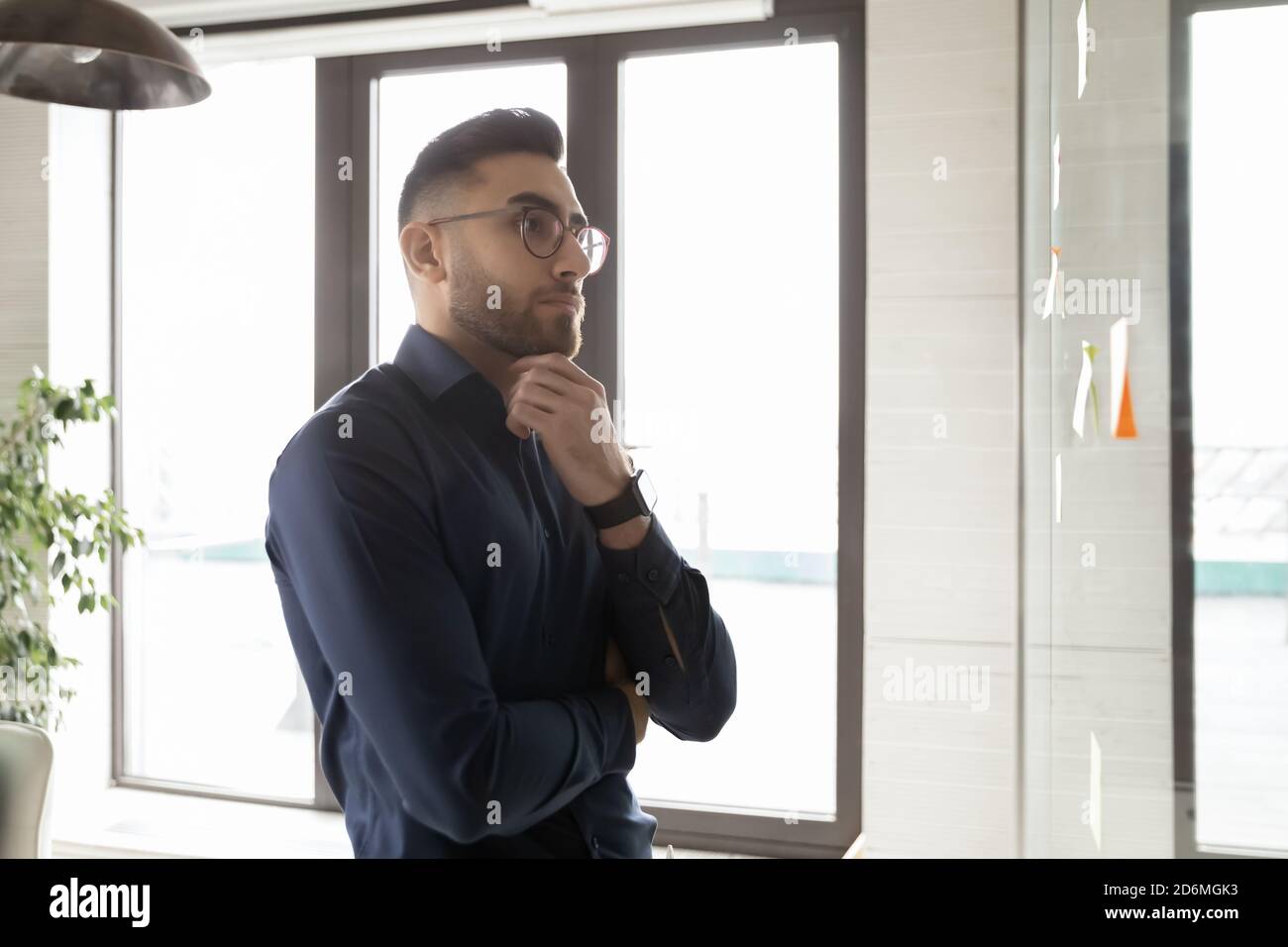 Pensive young arab middle eastern ethnicity young businessman solving problem. Stock Photo