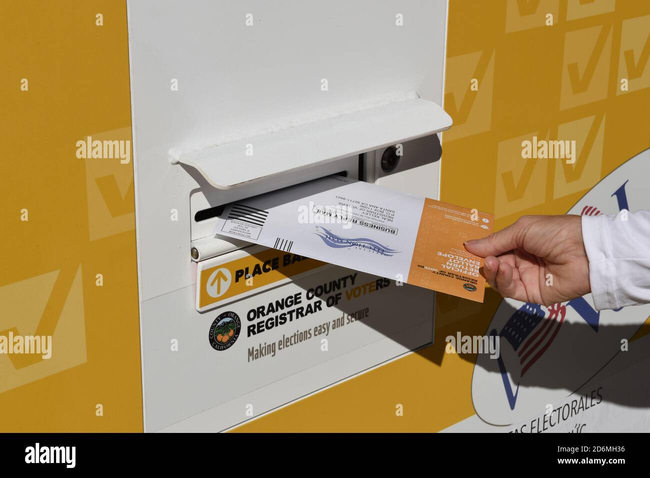 IRVINE, CALIFORNIA - 14 OCT 2020: Woman placing mail in ballot in an Official Ballot Drop Box in Harvard Park, Irvine, Orange County, California. Stock Photo