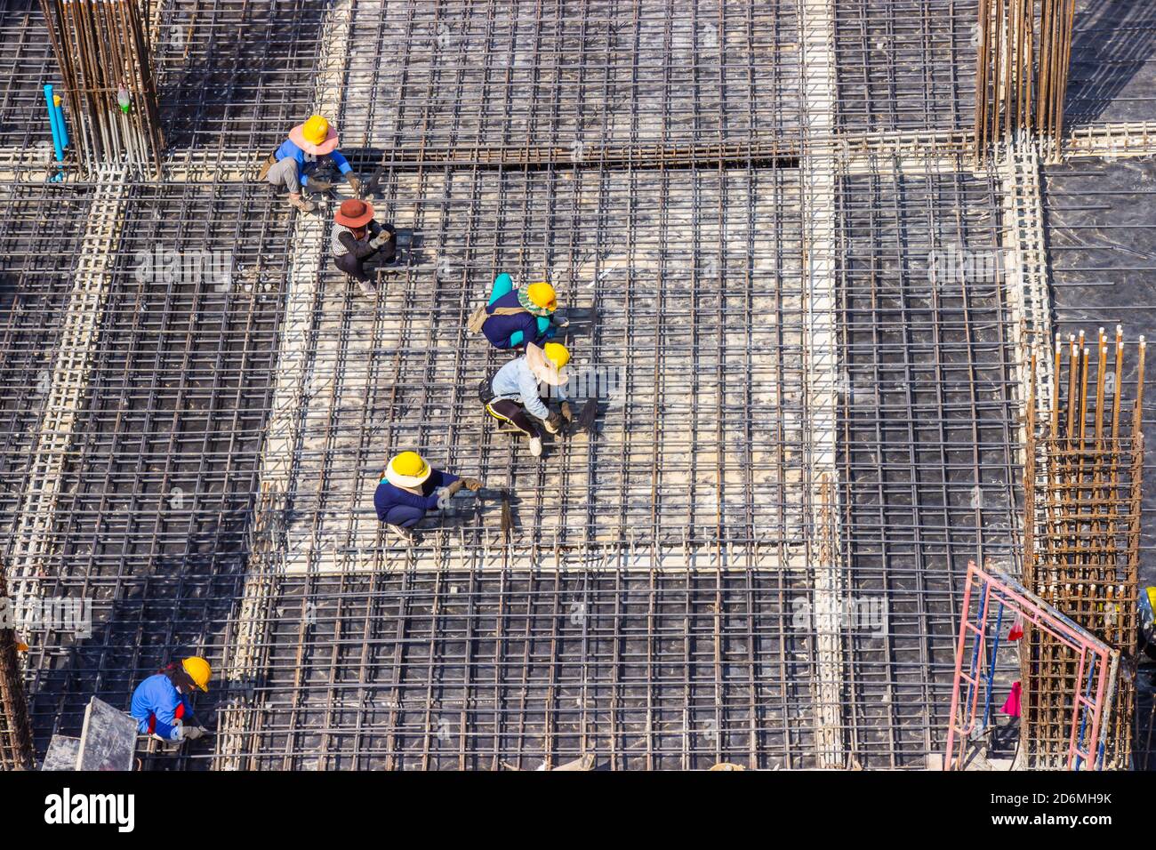 Construction workers fabricating large steel bar reinforcement bar at