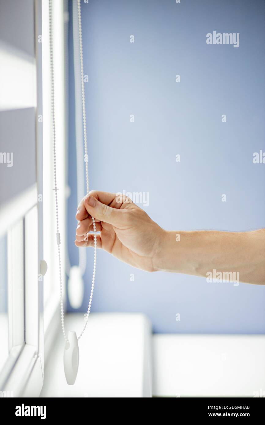 Man testing cassette roller blinds on windows. Stock Photo