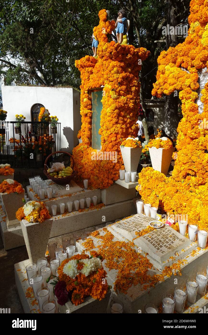 Marigolds known in Mexico, as 'the flower of the dead' decorate graves in Patzcuaro during Day of the Dead when families remember their loved ones. Stock Photo