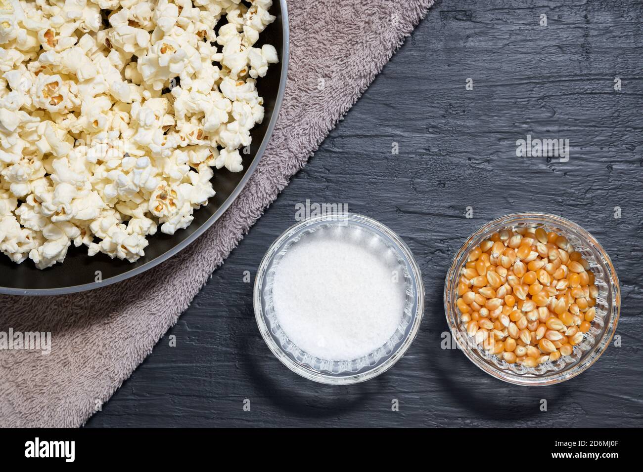 Popcorn in a pan next to corn kernels and salt Stock Photo Alamy