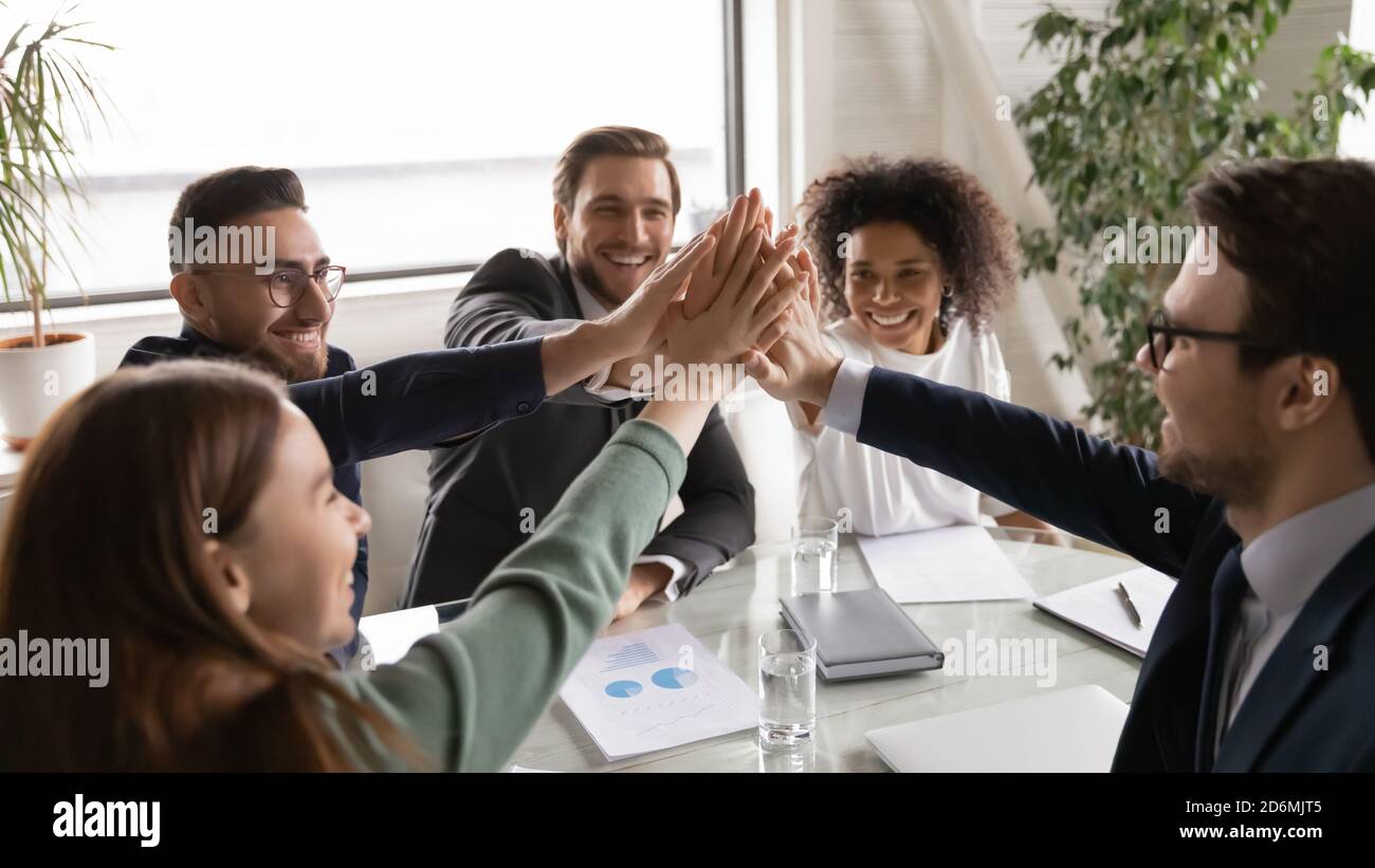 Positive happy young multiracial diverse colleagues giving high five ...