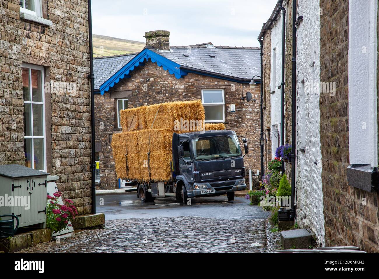 Wagon loaded full of hay / straw bales driving through the Cumbrian village of Dent in Dentdale