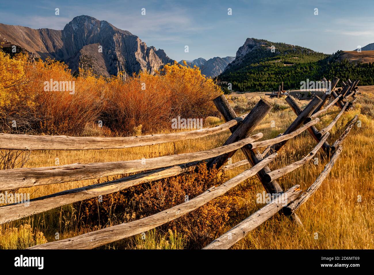 Fall colors with fence leading to distant mountain range in Idaho Stock Photo