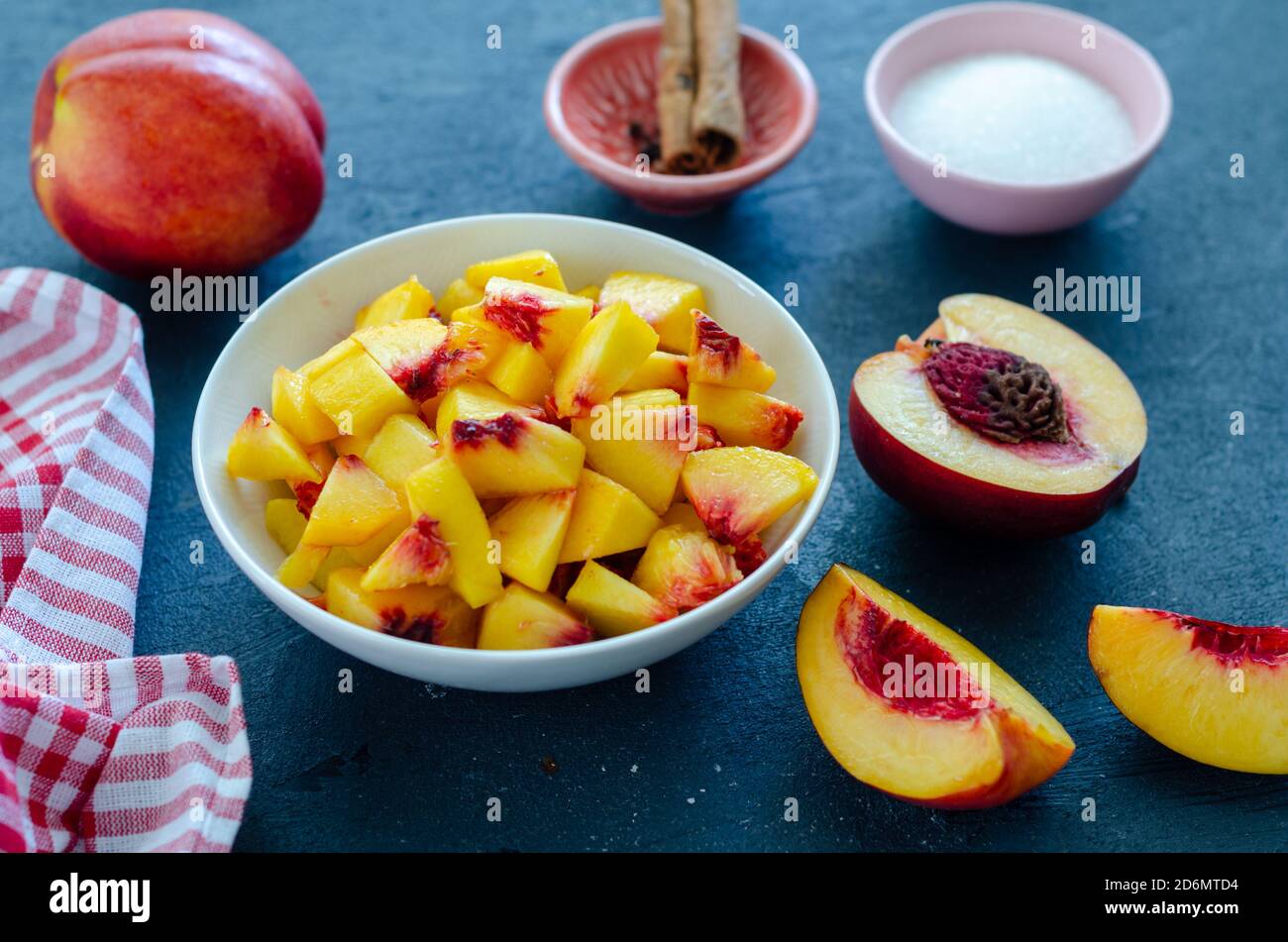 Chopped peaches and whole peache on a  table,  closeup. It is ready to make compote or jam Stock Photo