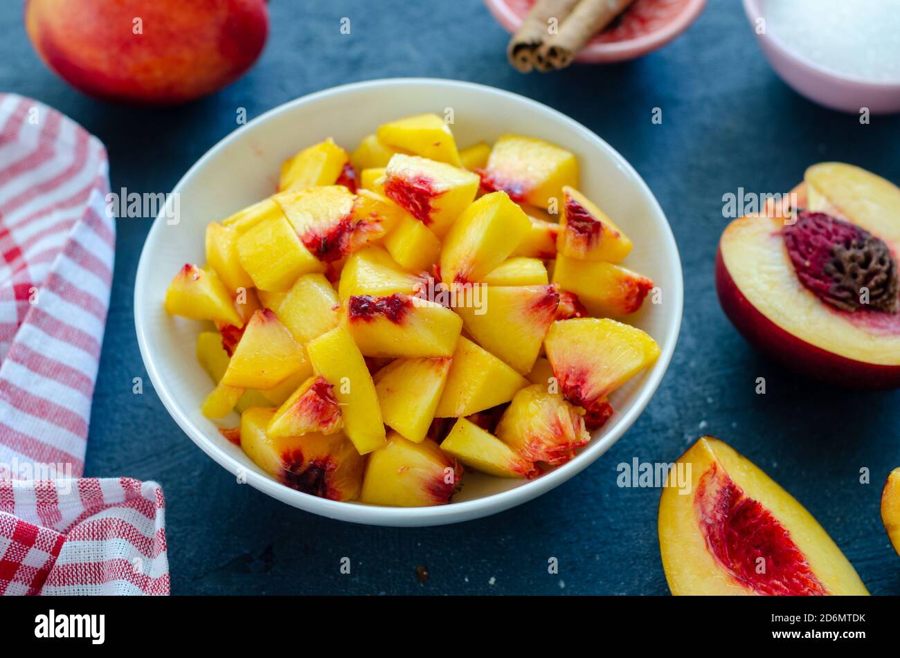 Chopped peaches and whole peache on a  table,  closeup. It is ready to make compote or jam Stock Photo