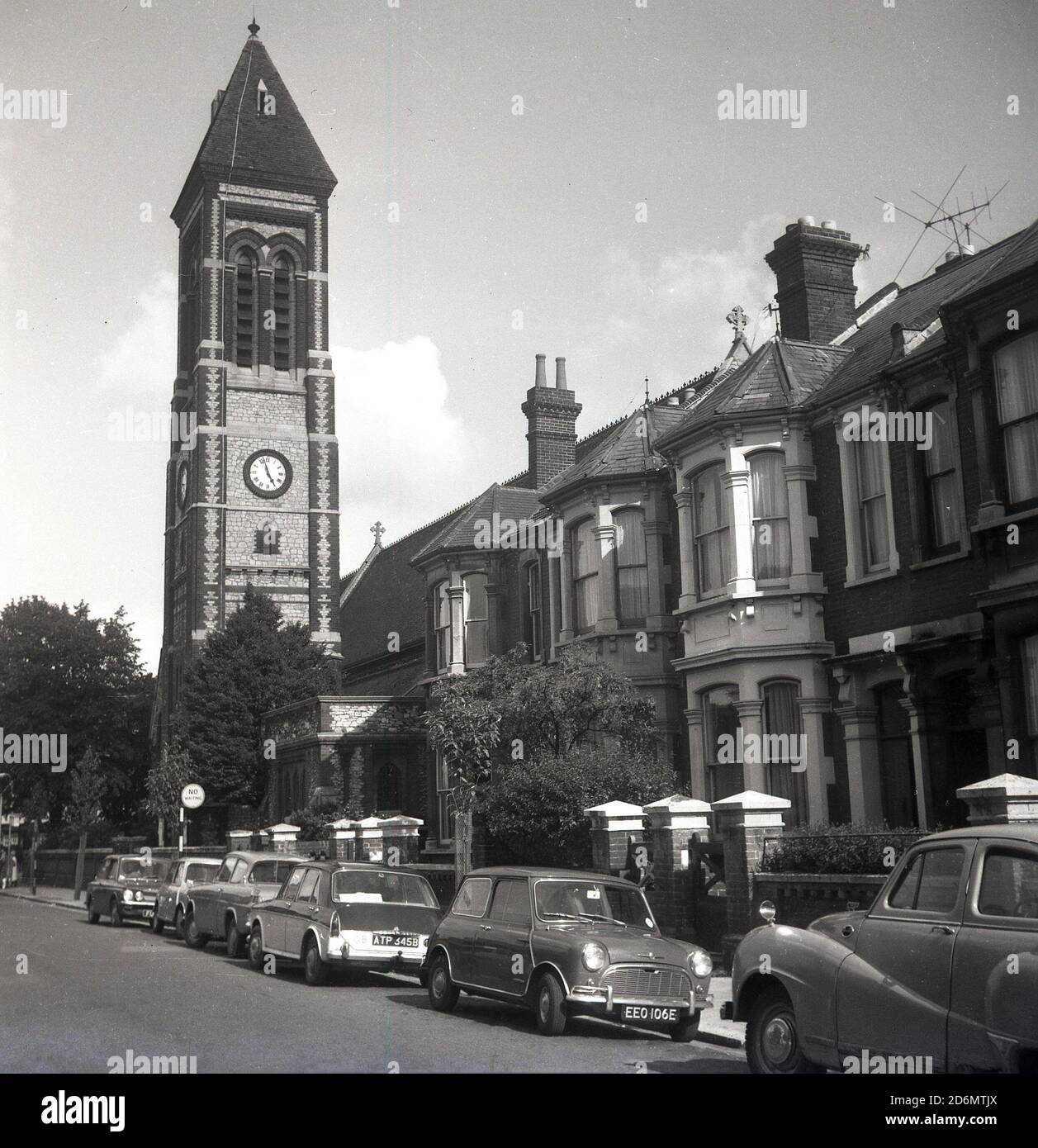 1970s, historical, South East London, Suburban street with cars of the era parked and church tower with clock. Stock Photo