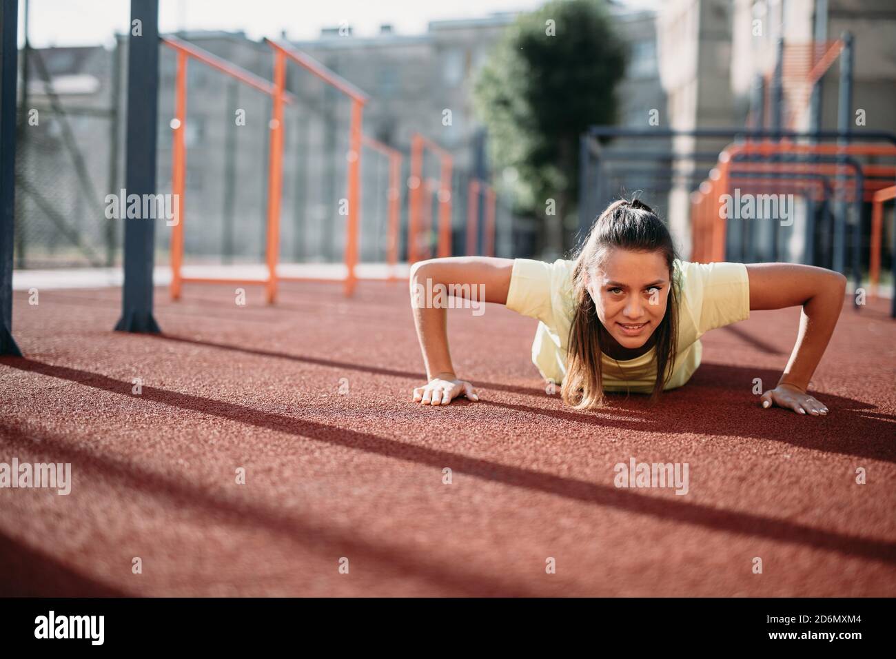 Attractive fit woman doing push up from ground at stadium Stock Photo