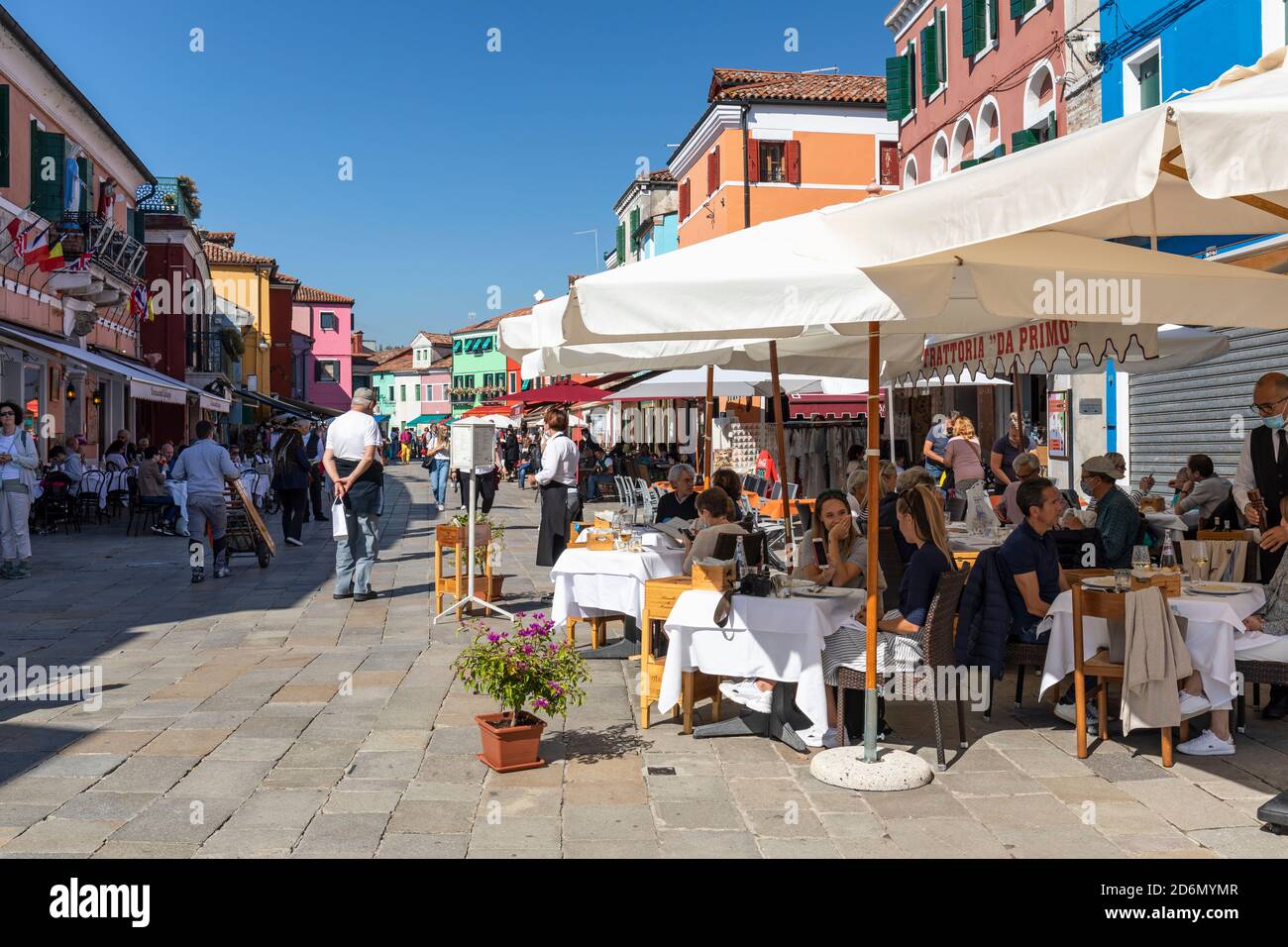 Tourist dining outside at Trattoria da Primo e Paoloin the centre of Baldassare Galuppi Square, Burano, Venice Stock Photo