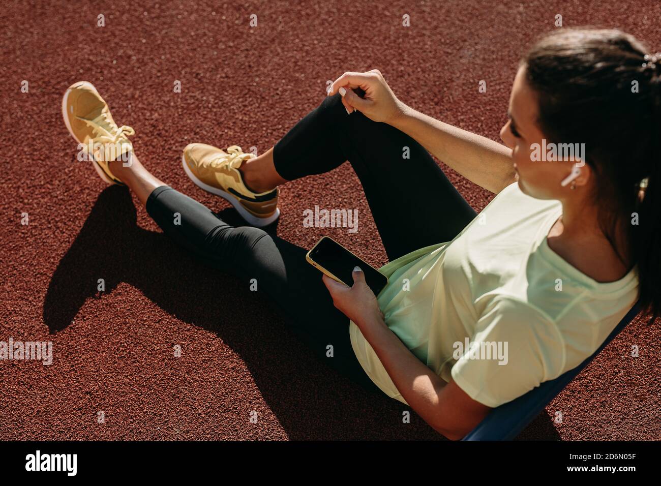 Beautiful woman with mobile having break on stadium Stock Photo