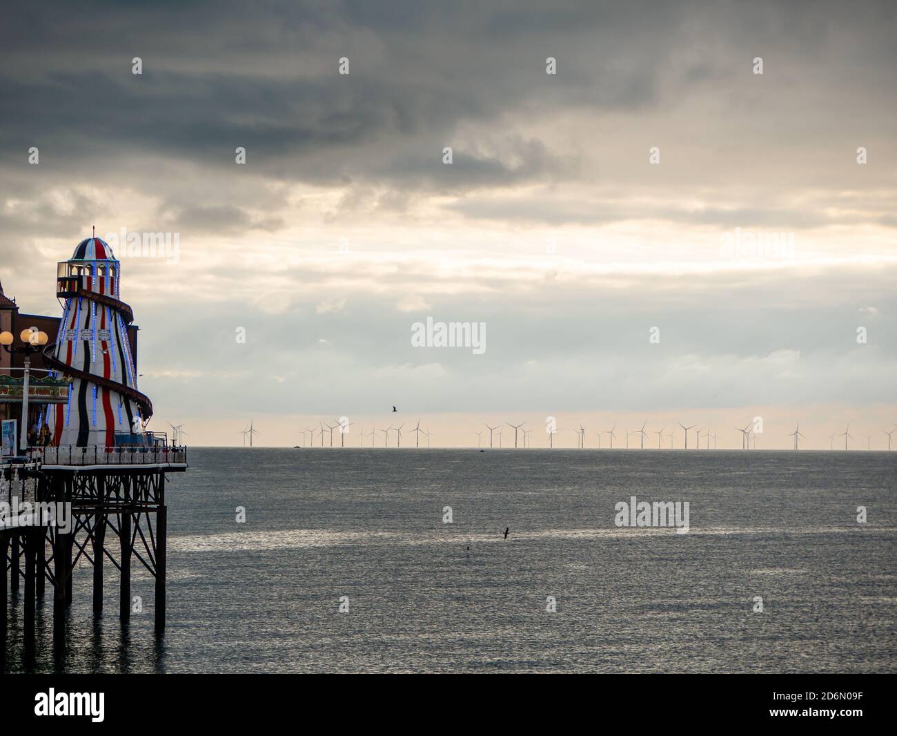 Old and new towers. Helter Skelter and wind turbines at dusk Stock Photo
