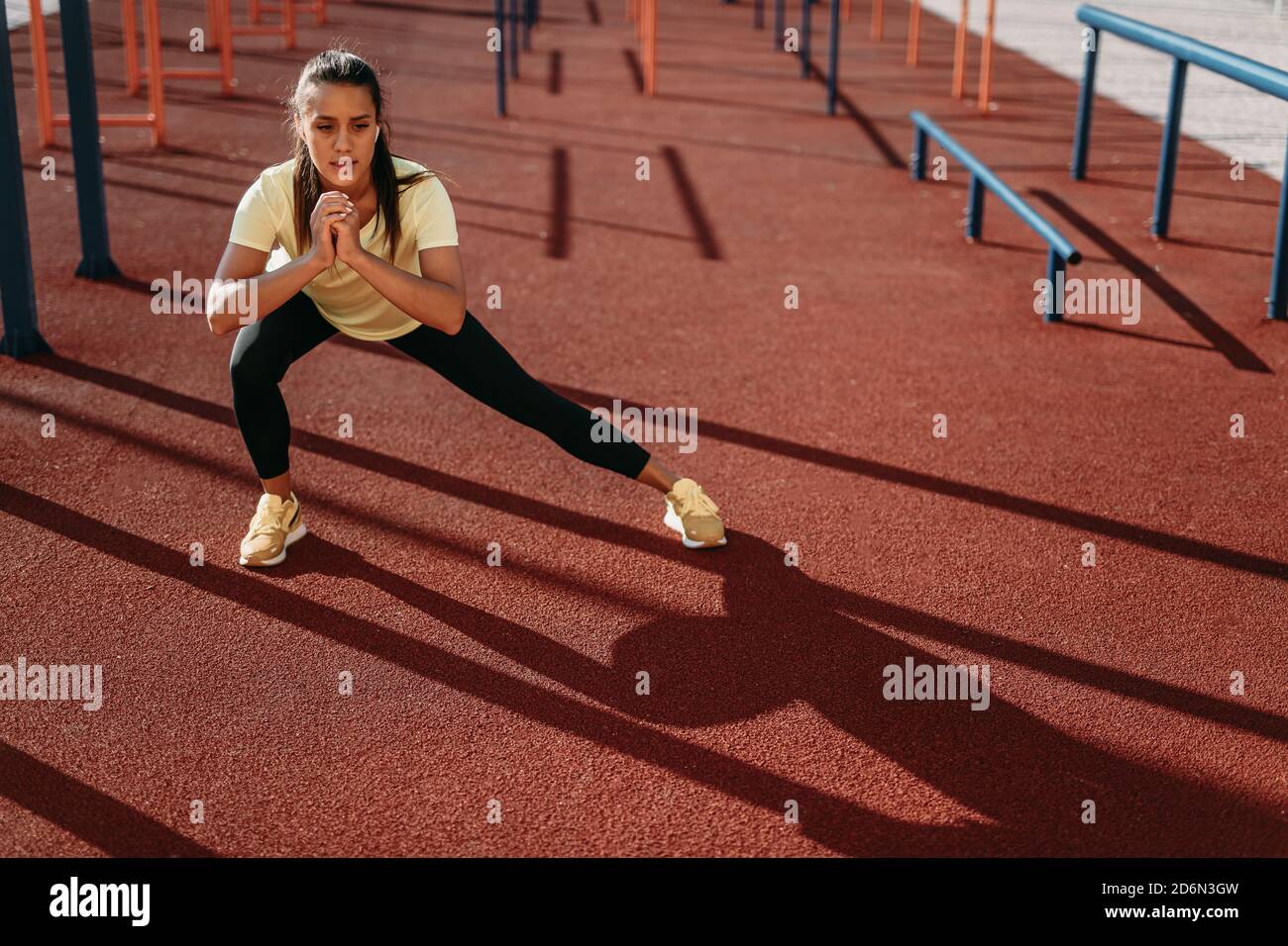 Attractive young brunette training legs outdoors Stock Photo